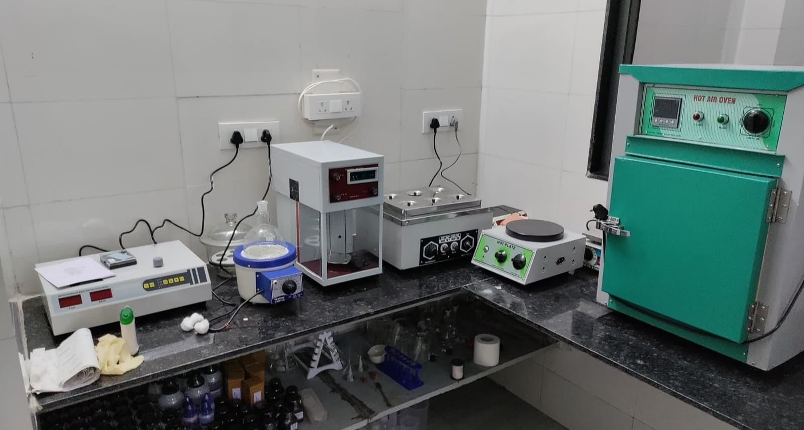 Laboratory bench with hot air oven, hot plate, water bath, balance and glassware